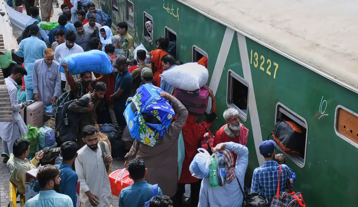 Terbatasnya moda transportasi menjadi salah satu penyebab melonjaknya pemudik kereta api. Tampak dalam foto, orang-orang menaiki kereta penumpang untuk pulang ke kampung halaman untuk Hari Raya Idul Fitri yang akan datang, sekaligus menandai berakhirnya bulan suci Ramadan, di sebuah stasiun kereta api di Karachi, Pakistan, Selasa 17 Maret 2026. (AP Photo/Ali Raza)