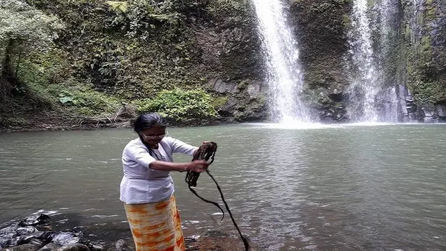 Juru kunci air terjun talondo Toraja, Indo Talondo sedang membilas rambut panjangnya (Liputan6.com/ Eka Hakim)