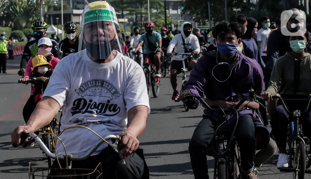 Warga berolahraga di area Car Free Day (CFD) kawasan MH Thamrin, Jakarta, Minggu (21/6/2020). Hari ini adalah kali pertama digelarnya CFD Jakarta di sepanjang Jalan Sudirman - Thmarin saat Pembatasan Sosial Berskala Besar (PSBB) Masa Transisi. (Liputan6.com/Johan Tallo)