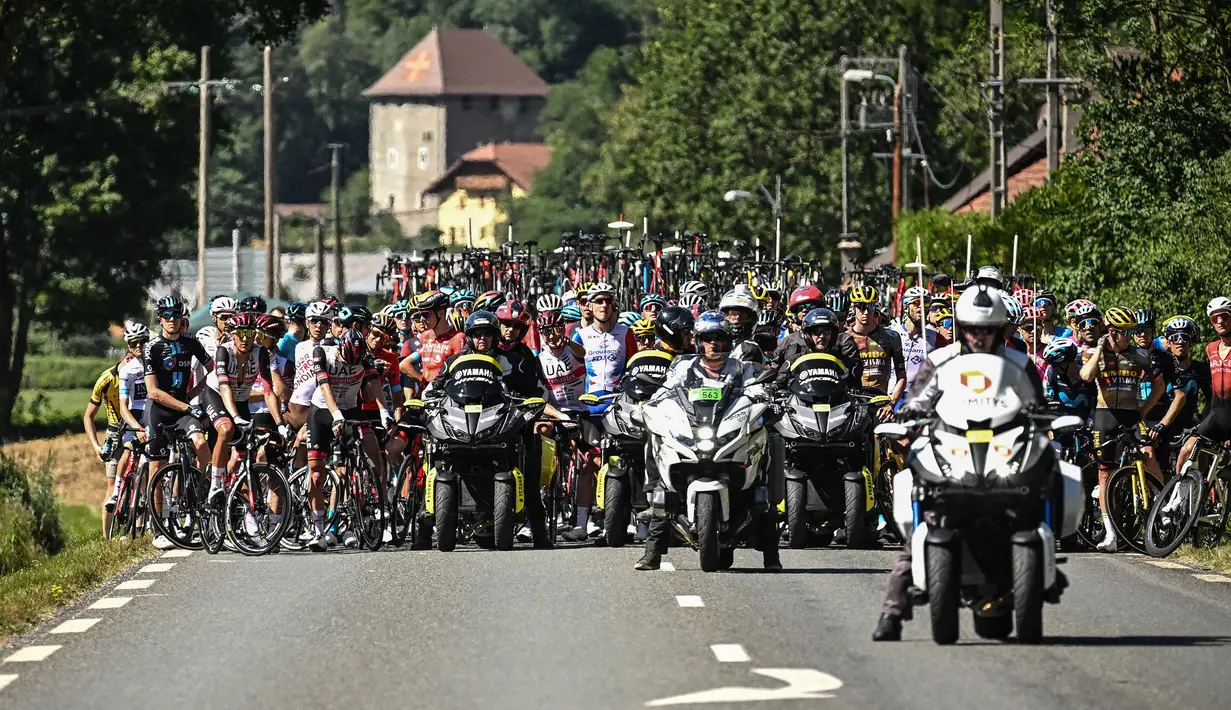 Rombongan pebalap dihentikan semenatara oleh regulator balapan karena terjadi demonstrasi perubahan iklim yang menutup rute balapan pada etape ke-10 Tour de France, antara Morzine dan Megeve, di Pegunungan Alpen Prancis, pada 12 Juli 2022. (AFP/Marco Bertorello)