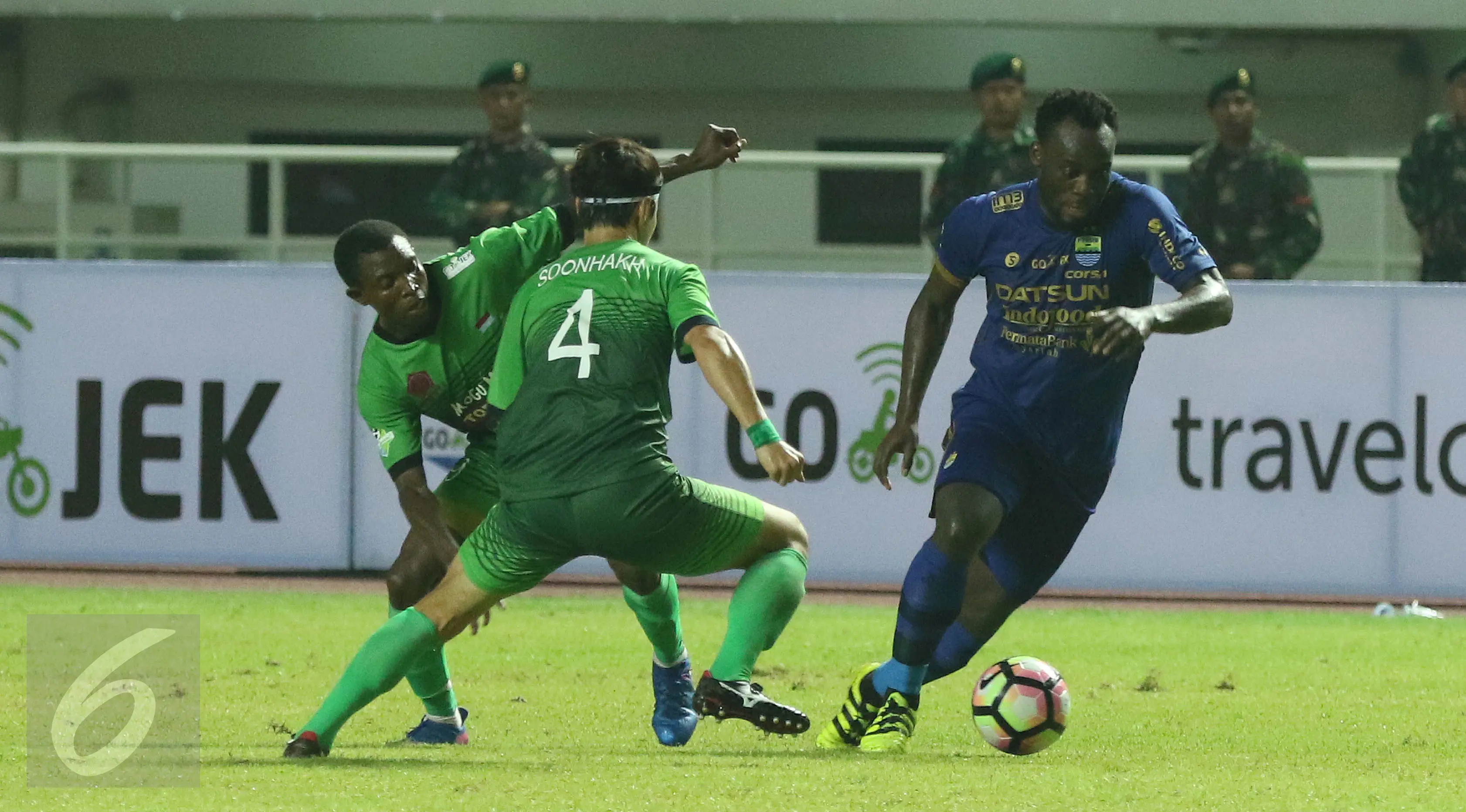 Gelandang Persib, Michael Essien (kanan) melewati dua pemain PS TNI pada lanjutan Liga 1 di Stadion Pakansari, Kab Bogor, Sabtu (22/4). PS TNI bermain imbang Persib 2-2. (Liputan6.com/Helmi Fithriansyah)