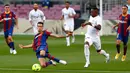 Gelandang Barcelona Sergio Busquets dan penyerang Real Madrid, Vinicius Junior berebut bola pada laga La Liga bertajuk El Clasico di Nou Camp, Sabtu (24/10/2020). Barcelona harus menelan pil pahit kalah 1-3 dari musuh bebuyutannya Real Madrid di kandang sendiri, Nou Camp. (AP Photo/Joan Monfort)