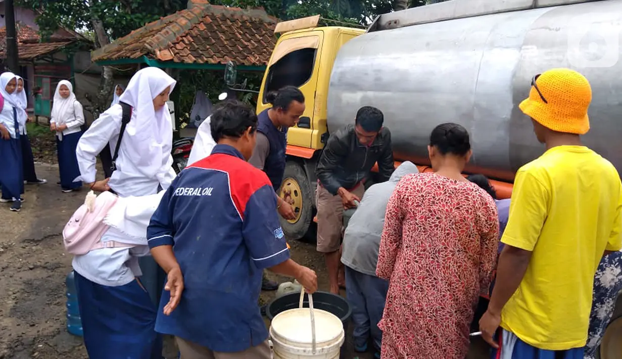Warga korban banjir dan tanah longsor antre untuk mendapatkan air bersih di Lebak, Banten Senin (6/1/2020). Sebagai wujud kepedulian, Askrindo Syariah memberikan bantuan berupa air bersih melalui mobil tangki air dengan kapasitas sebesar 8.000 liter. (Liputan6.com/Pool/Askrindo)