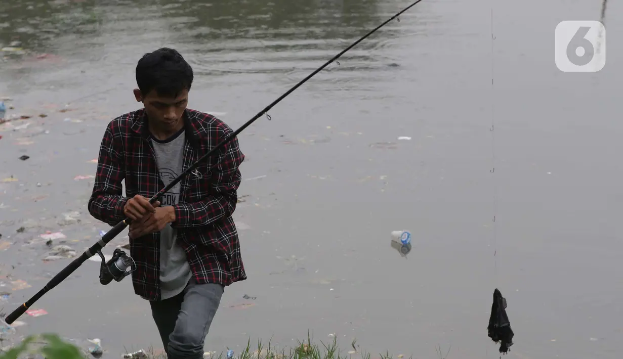 Warga memancing di bibir Waduk Cincin, Jakarta, Sabtu (19/6/2021). Ceceran sampah plastik ini mengganggu kemyamanan warga yang ingin menikmati suasana Waduk Cincin . (Liputan6.com/Helmi Fithriansyah)
