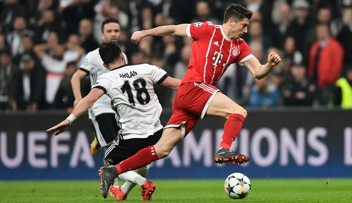 Striker Bayern Munchen Robert Lewandowski membawa bola melewati pemain Besiktas saat pertandingan Liga Champions leg kedua di stadion Vodafone Arena di Istanbul (14/3). Munchen menang 3-1 atas Besiktas. (AFP/Ozan Kose)