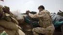 Seorang pejuang Yaman yang didukung oleh koalisi pimpinan Arab Saudi menembakkan senjatanya ke garis depan di Marib, Yaman, 19 Juni 2021. (AP Photo/Nariman El-Mofty)