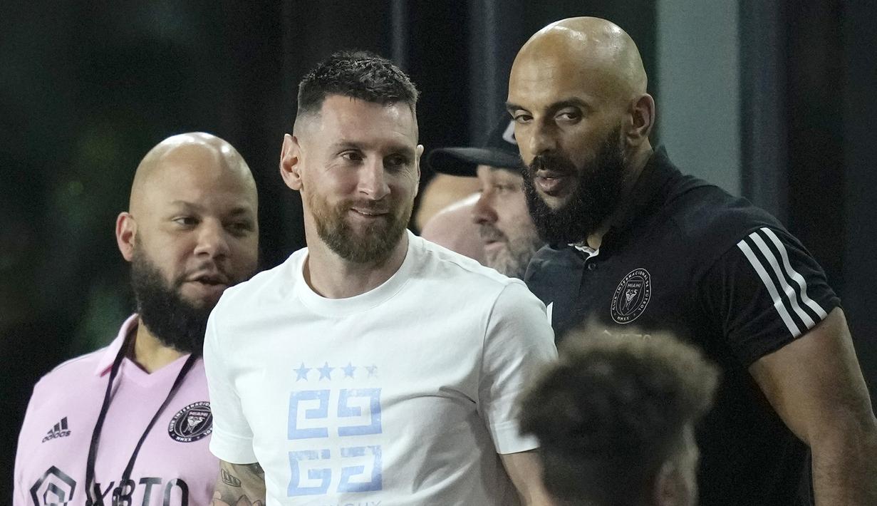 Pemain Inter Miami, Lionel Messi (tengah) didampingi pengawal pribadi,Yassine Cheuko (kanan), saat menyaksikan timnya melawan Charlotte FC pada lanjutan kompetisi Major League Soccer 2023/2024 yang berlangsung di DRV PNK Stadium, Kamis (19/10/2023). Lionel Messi, yang baru kembali dari tugas internasional, menonton perjuangan rekan-rekannya dari bangku VIP. (AP Photo/Rebecca Blackwell)