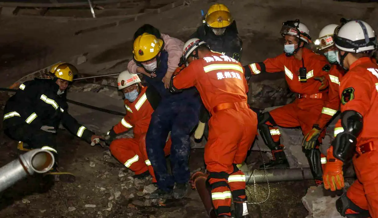 Seorang perempuan diselamatkan dari puing-puing sebuah hotel yang runtuh di Quanzhou, China, Sabtu (7/3/2020). Sekitar 70 orang terjebak di hotel Xinjia yang akhir-akhir ini digunakan sebagai tempat karantina untuk orang-orang yang berhubungan dengan pasien virus corona. (STR/AFP)