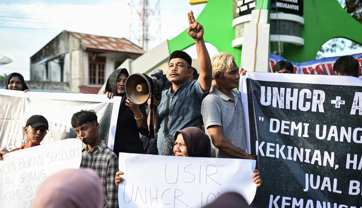 Para pengunjuk rasa memegang poster saat unjuk rasa di Sabang, Provinsi Aceh, Indonesia, Senin (18/12/2023). (AP Photo/Reza Saifullah)