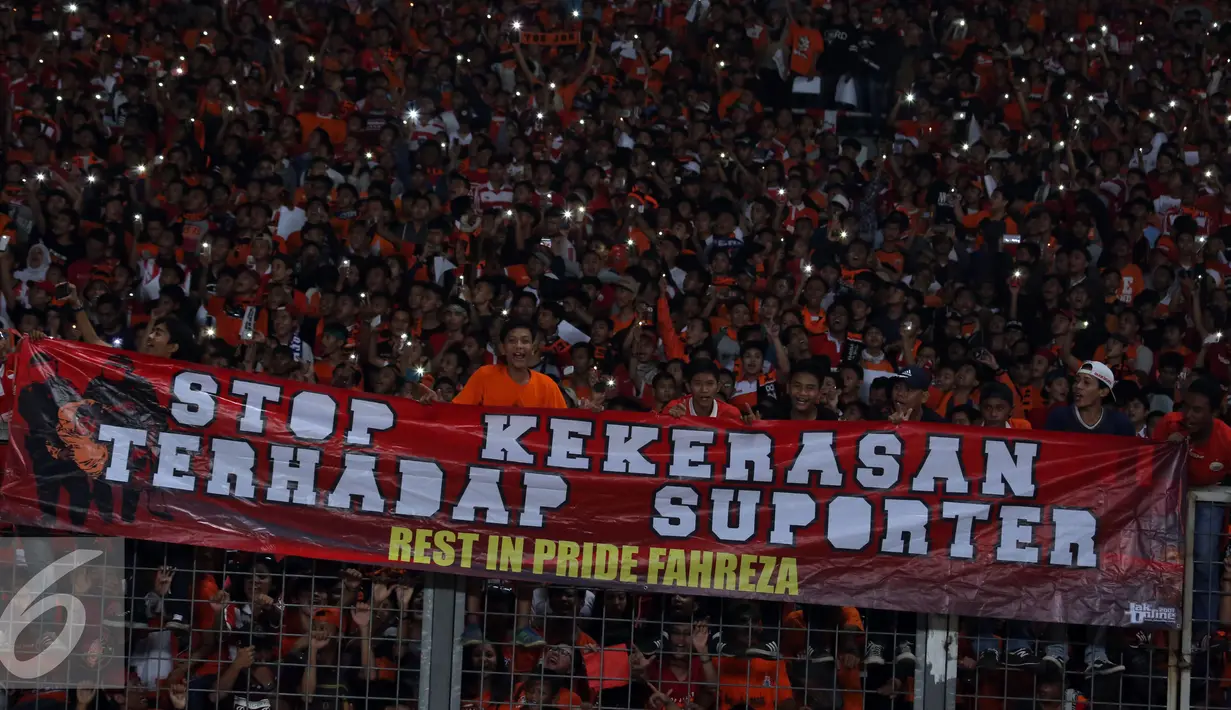 Suporter membentangkan spanduk jelang menyaksikan laga Persija melawan PS TNI di Stadion GBK Jakarta, Jumat (10/6). Mereka meminta pengungkapan kasus tewasnya M Fahreza saat akanmenyaksikan laga Persija (13/5) lalu. (Liputan6.com/Helmi Fithriansyah)