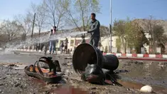 Petugas pemadam kebakaran membersihkan lokasi pemboman bunuh diri di dekat Universitas Kabul, Afghanistan, (21/3). Pembom bunuh diri itu menyerang di jalan menuju kuil Syiah di ibukota Afghanistan. (AP Photo/Rahmat Gul)
