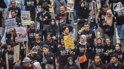 Massa Serikat Pekerja Container (SPC) membawa sejumlah poster saat menggelar karnaval pelabuhan di area CFD, Jalan Thamrin, Jakarta, Minggu (17/2). Massa menolak liberalisasi pengelolaan Pelabuhan Tanjung Priok oleh vendor asing. (Liputan6.com/HO/Mico)