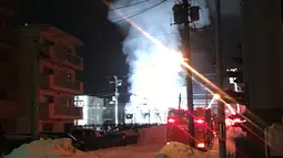 Kepulan asap terlihat dari kebakaran yang melanda panti jompo di Sapporo, utara Jepang, Kamis (1/2). Ada sebanyak 16 orang yang tinggal di pantai jompo dengan biaya sewa sebanyak 36 ribu yen atau setara rp 4,4 juta tersebut. (JIJI PRESS / AFP)
