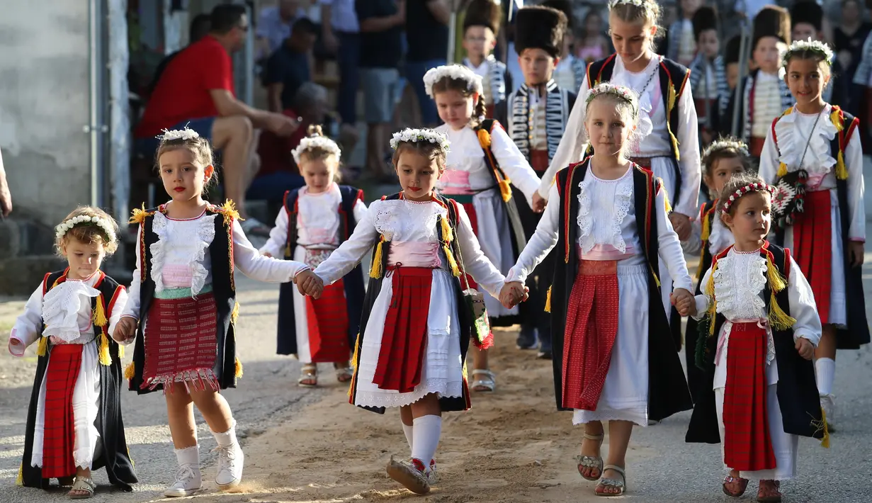 Anak-anak perempuan yang mengenakan kostum tradisional melakukan pawai sebelum Turnamen Alka Anak-Anak di Brnaze, Kroasia (23/8/2020). (Xinhua/Pixsell/Ivo Cagalj)