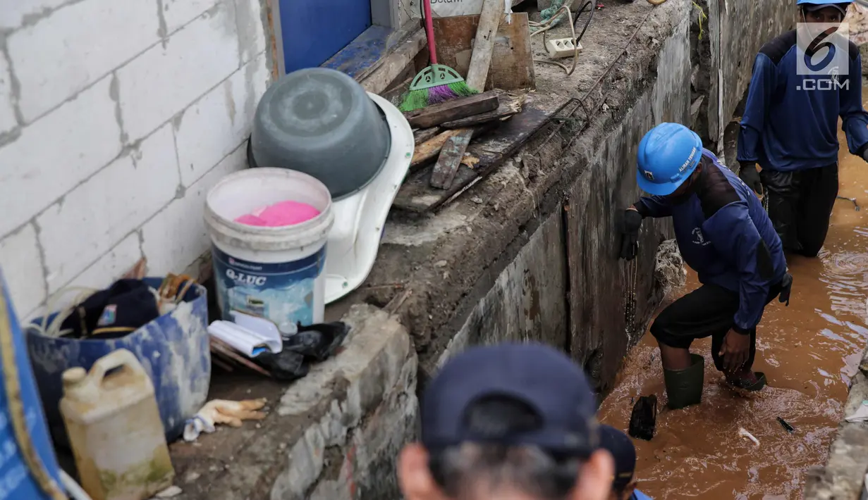 Petugas Sudin Sumber Daya Air Jakarta Utara mengatasi tanggul jebol di kawasan Luar Batang, Penjaringan, Rabu (8/11). Tanggul penahan air laut rob tersebut jebol karena tidak mampu menahan debit air yang terus meningkat. (Liputan6.com/Faizal Fanani)