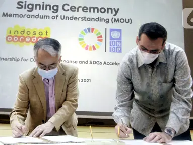 Resident Representative UNDP Indonesia, Norimasa Shimomura (kiri) dan Presdir & CEO Indosat Ooredoo, Ahmad Al-Neama (kanan) menandatangani MoU penanggulangan pandemi COVID-19 dan percepatan pencapaian Tujuan Pembangunan Berkelanjutan (SDGs) di Jakarta, Rabu (31/3/2021). (Liputan6.com/Pool/Indosat)