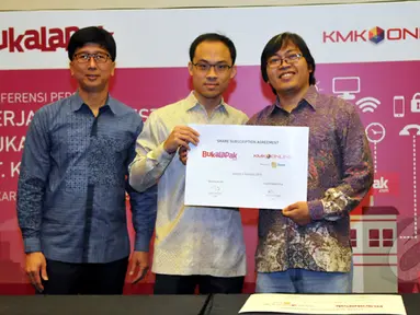 CEO EMTEK Group Sutanto Hartono (kiri),  CEO KMK Adi Sariaatmadja (tengah) dan CEO Bukalapak Achmad Zaky (kanan) menunjukkan dokumen kerjasama antara Bukalapak.com dengan PT.KMK Online, Jakarta, Rabu (4/1/2015). (Liputan6.com/Panji Diksana)
