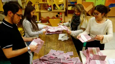 Relawan menghitung surat suara untuk Referendum Reformasi Konstitusi di sebuah TPS di Roma, Italia, Minggu (4/12). Warga Italia memilih menolak rencana Reformasi Konstitusi. (REUTERS / Tony Gentile)