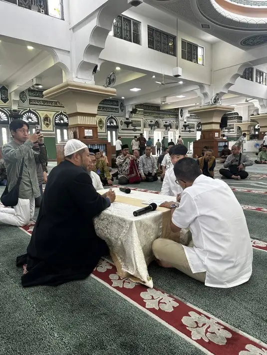 Rachell Yahya melalui akun Twitternya membagikan momen saat Park Yong Gwang memeluk agama Islam di Masjid Al-Azhar, Jakarta. Helmy Yahya dan Park Yong Gwang tampil dengan kemeja putih panjang.  [Twitter/@rachellyahya]