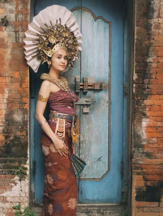 Ia juga tampil dengan kemben dengan bawahan kain lengkap dengan aksesori dari kepala, kaling, hingga gelang seperti perempuan Bali. [@michelleziu]