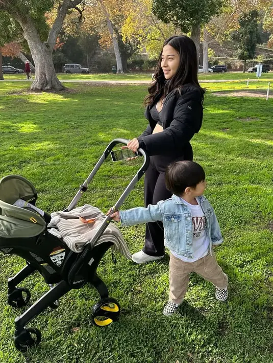 Sambil mendorong stroller putranya, Nikita pun mengenakan atasan jaket puffer crop dipadukan inner bra top dan celana panjang ketat. Rambutnya terurai wavy. [@yorafebrina]