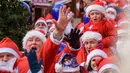 Peserta mengambil bagian dalam Santa's Fun Run di Riga, Latvia, Minggu (8/12/2019). Ini merupakan acara amal yang pesertanya bersenang-senang dengan berlari atau berjalan kaki sambil mengenakan kostum Sinterklas untuk mengumpulkan dana bagi anak-anak di rumah sakit Latvia. (Gints Ivuskans/AFP)