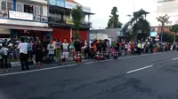 Para Pecalang Bali turut membantu mengamankan warga yang ingin melihat iringan mobil Raja Salman.