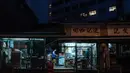 Pekerja menyiapkan makanan di dalam 'dai pai dong' (sebuah restoran terbuka) pada subuh hari di distrik Kwai Chung, Hong Kong (25/5/2019). Kwai Chung adalah situs pelabuhan peti kemas. Ini juga merupakan bagian dari Kota Baru Tsuen Wan. Pada tahun 2000, ia memiliki populasi 287.000. (AFP Photo/Phili