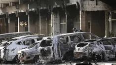 Petugas kepolisian memeriksa mobil yang hangus terbakar pasca teror di luar hotel Splendid, Ouagadougou , Burkina Faso, (16/1). Petugas berhasil merebut kembali lokasi dimana beberpa kelompok al Qaeda menyandera beberapa orang. (REUTERS / Joe Penney)