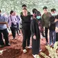 Ibu korban didampingi keluarganya saat mengikuti pemakaman 4 anak yang tewas dibunuh ayahnya, di TPU Bedahan, Sawangan, Kota Depok. (Liputan6.com/Dicky Agung Prihanto)