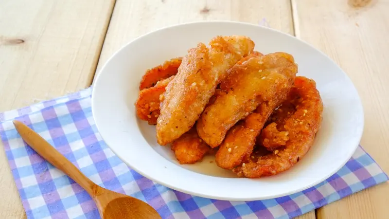 Pisang goreng madu yang manis dan renyah, disajikan hangat dengan taburan keju parut dan madu yang menggugah selera