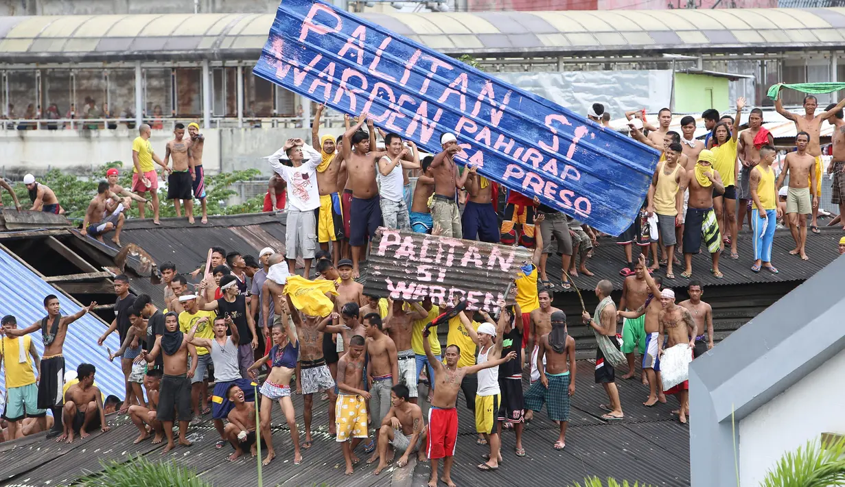 Ratusan Narapidana berkumpul di atap penjara saat unjuk rasa menuntut penggantian kepala penjara di Manila City Jail, Filipina (13/10). Para narapidana mengelar aksi nekat dengan menaiki atap penjara dan membentangkan spanduk protes. (REUTERS/Stringer)
