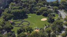Ribuan orang mencoba memecahkan rekor dunia untuk rantai manusia terpanjang dalam bentuk tanda perdamaian di New York Central Park, Selasa (6/10). Kegiatan itu menandai ulang tahun John Lennon ke-75. (REUTERS/NYonAir/Paul GaNun)