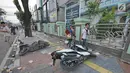 Pejalan kaki melintas di dekat dua motor yang rusak pascakerusuhan di sekitaran Jakarta, Kamis (23/5/2019). Aksi unjuk rasa itu dilakukan menyikapi putusan hasil rekapitulasi nasional Pemilu serentak 2019. (Liputan6.com/Herman Zakharia)