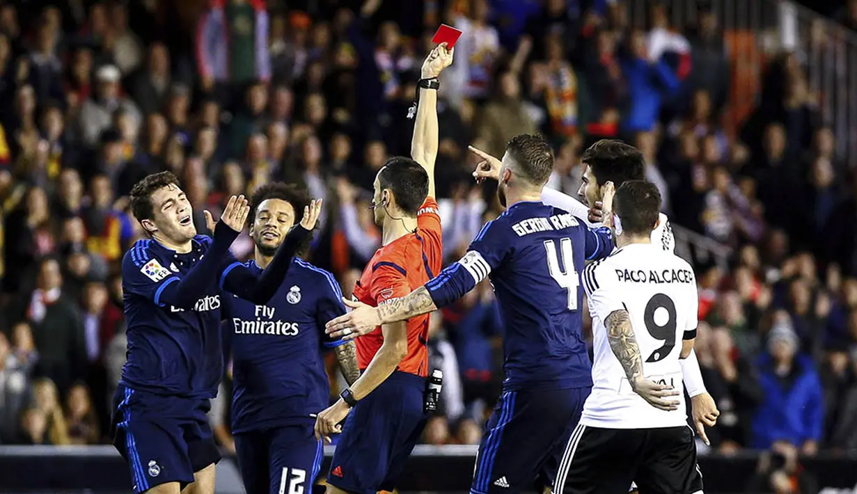 Wasit Sanchez Martinez memberikan kartu merah kepada gelandang Real Madrid, Mateo Kovacic, pada laga La Liga Spanyol. Sejak menit ke-68, Real Madrid hanya bermain 10 orang menghadapi Valencia. (EPA/Biel Alino)