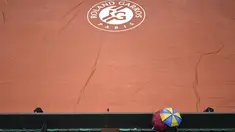 Penonton menggunakan payung menyaksikan lapangan Roland Garros yang ditutup tarpal saat hujan pada turnamen Prancis Terbuka 2016 di Roland Garros, (28/5/2016). (AFP/Philippe Lopez)