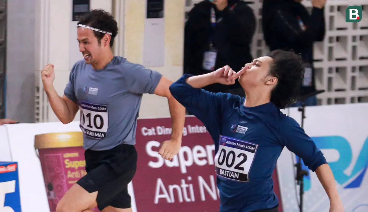 Selebritas Indonesia, Bastian Steel (kanan) melakukan selebrasi di samping Tarra Budiman menjelang garis finis lari 100 meter putra Turnamen Olahraga Selebriti Indonesia (TOSI) di GOR UNJ, Rawamangun, Jakarta, Minggu (30/07/2023). Bastian sukses finis tercetap dengan catatan waktu 16,32 detik. (Bola.com/Bagaskara Lazuardi)