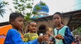 Anak-anak bermain kembang api di dekat tenda-tenda yang didirikan untuk para korban banjir di kompleks sebuah masjid, Meurah Dua, Kabupaten Pidie Jaya, Provinsi Aceh, pada 21 Februari 2026, setelah banjir dan tanah longsor dahsyat melanda Sumatra, akhir November 2025 lalu. Bulan Ramadan 1447 Hijriah atau 2026 Masehi dijalani dengan penuh keprihatinan oleh warga di Kabupaten Pidie Jaya, Provinsi Aceh. (CHAIDEER MAHYUDDIN/AFP)