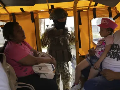 Seorang tentara mengintip ke dalam transportasi umum pada pemeriksaan keamanan yang ditempatkan oleh tentara di Duran, di seberang jembatan dari Guayaquil, Ekuador, Senin, 14 Agustus 2023. (AP Photo/Martin Mejia)