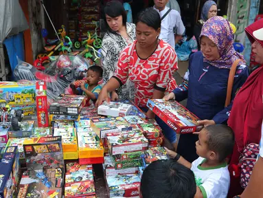 Sejumlah pembeli memilih mainan anak yang dijual di Pasar Gembrong, Jakarta, Jumat (8/7). Libur lebaran banyak dimanfaatkan orang tua untuk mengajak anaknya berbelanja aneka mainan murah. (Liputan6.com/Angga Yuniar)