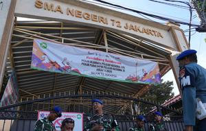 Personel militer berjaga di gerbang sebuah sekolah setelah ledakan di Jakarta, Indonesia, Minggu, 9 November 2025. Hingga Minggu (9/11/2025), SMAN 72 Jakarta di Kelapa Gading, Jakarta Utara, masih dijaga ketat Polisi Militer TNI Angkatan Laut (POMAL). (AP Photo/Achmad Ibrahim)