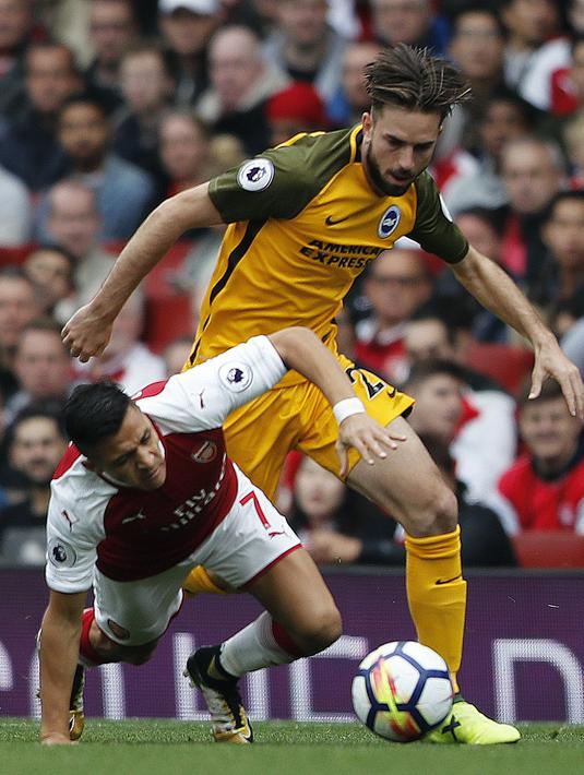 Pemain Arsenal, Alexis Sanchez (kiri) terjatuh saat berebut bola dengan pemain Brighton, Davy Propper pada lanjutan Premier League di Emirates Stadium, London, (1/10/2017). Arsenal menang 2-0. (AP/Frank Augstein)
