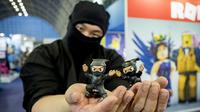 Seorang pria berkostum ninja berpose dengan mainan saat Toy Fair  atau Pameran Mainan tahunan di Olympia, London, Inggris, Selasa (23/1). (AFP PHOTO/Tolga AKMEN)