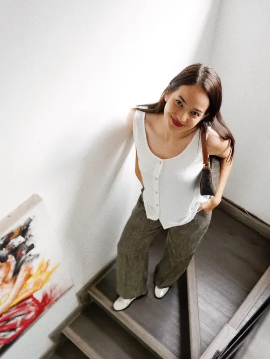 <p>Tak kalah menarik, cara Enzy memadukan tank top putih bisa ditiru. Gunakan bersama jeans kesayangan dan sneakers putih. [Instagram/enzystoria]</p>