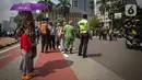 Antusias warga menyaksikan parade pembalap MotoGP di kawasan Jakarta, Rabu (16/3/2022).  Gelaran parade MotoGP di Jakarta dalam rangka penyambutan event MotoGP Mandalika 2022. (Liputan6.com/Faizal Fanani)