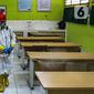 Petugas PMI menyemprotkan disinfektan di salah satu ruang SMPN 97 Jakarta, Kamis (3/2/2022). Pemerintah Provinsi DKI Jakarta mengeluarkan kebijakan untuk memberhentikan PTM di tengah melonjaknya kasus COVID-19 di DKI Jakarta. (Liputan6.com/Faizal Fanani)