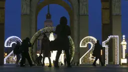 Orang-orang berjalan melintasi instalasi lampu yang dipasang untuk menyambut libur Tahun Baru dan Natal Ortodoks di Moskow, Rusia, pada 29 Desember 2020. (Xinhua/Alexander Zemlianichenko Jr)