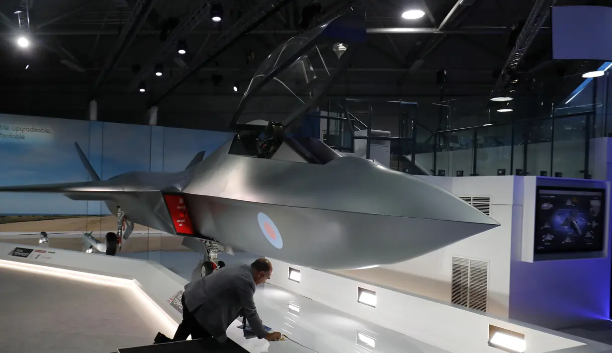Seorang pria memeriksa jet tempur baru 'Tempest' di London, (16/7). Jet tempur ini akan dirakit dengan sistem jet BAE Systems, perakit mesin Rolls-Royce, perusahaan dirgantara Italia Leonardo dan pakar rudal asal Prancis, MBDA. (AFP Photo/Tolga Akmen)