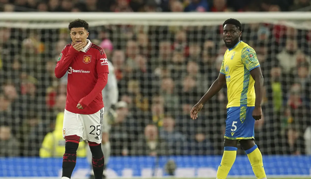 Penyerang Manchester United, Jadon Sancho dan Orel Mangala dari Nottingham Forest berdiri di lapangan selama pertandingan leg kedua semifinal Piala Liga Inggris di Old Trafford di Manchester, Inggris, Kamis (2/2/2023).  Sancho masuk untuk menggantikan Antony yang performanya memang tidak optimal. (AP Foto/Dave Thompson)