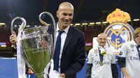 Zidane dan trofi Liga Champions 2017 usai kalahkan Juventus pada final di The Principality Stadium, Cardiff, (3/6/2017). Zinedine Zidane mundur dari kursi pelatih Madrid setelah meraih trofi Liga Champions tiga kali. (AFP/Filippo Monteforte)